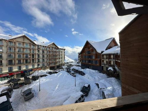 a snow covered city with buildings and cars parked at Giorgi Apartment In New Gudauri - Block 3 - N315 in Gudauri