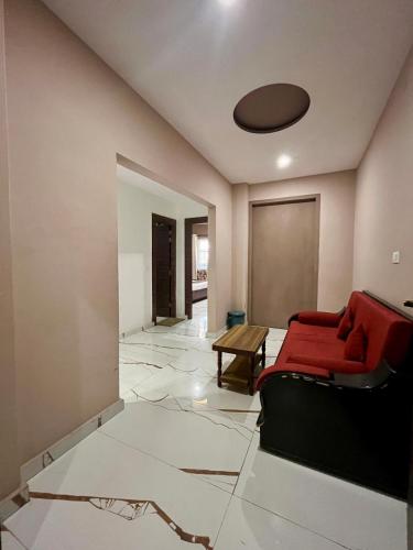 a living room with a red couch and a table at Hotel Viva La Vida in Dalhousie