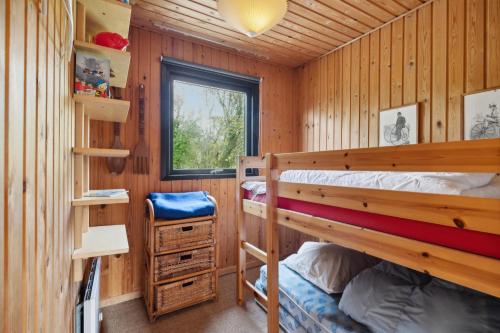 a bedroom with two bunk beds and a window at Feriehus 1070 in Ulfborg