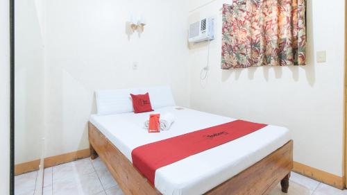 a white room with a bed with a red blanket at RedDoorz @ Golden Victory Hotel Mabalacat Pampanga in Mabalacat