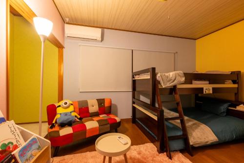 a bedroom with a bunk bed and a couch at すずかのおやど Suzuka Inn in Suzuka