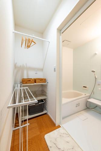 a white bathroom with a shower and a mirror at すずかのおやど Suzuka Inn in Suzuka
