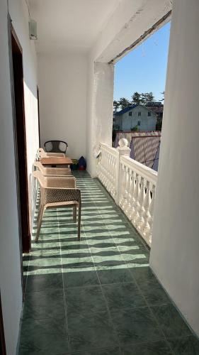 a balcony with a table and chairs on a balcony at Olympia Ureki Guria Street 24-26 in Ureki