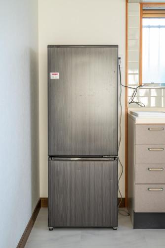 a stainless steel refrigerator in a kitchen at すずかのおやど Suzuka Inn in Suzuka