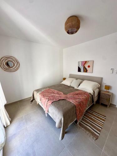 une chambre avec un grand lit dans une pièce blanche dans l'établissement Appartement HARMONIE, à Saint-Florent