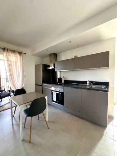 - une cuisine avec une table, une table et des chaises dans l'établissement Appartement HARMONIE, à Saint-Florent