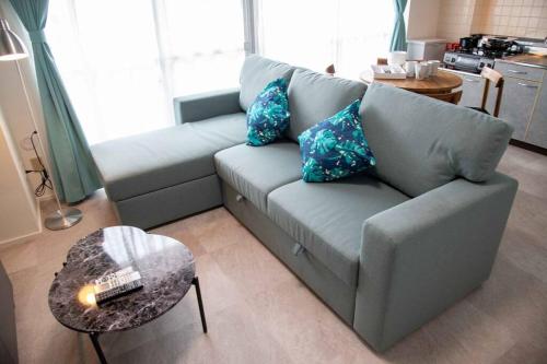 a living room with a couch and a table at 横須賀アロハハウス702 in Yokosuka