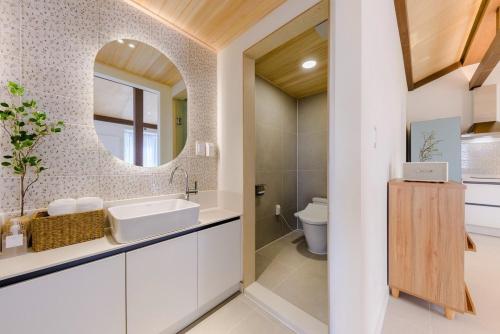 a bathroom with a sink and a mirror at Jeju Slow Stay in Jeju