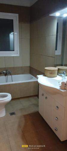 a bathroom with a tub and a toilet and a sink at Mountainside in Vounoplagiá