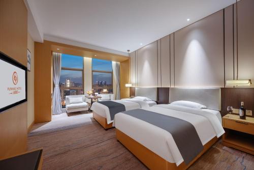 成都Chengdu Yunhao High-altitude Hotel的一间有两张床和一台平板电视的酒店房间