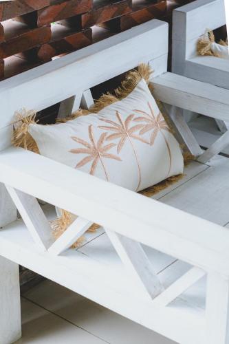 a white bench with two pillows on it at Gypsy Lust Ubud in Ubud