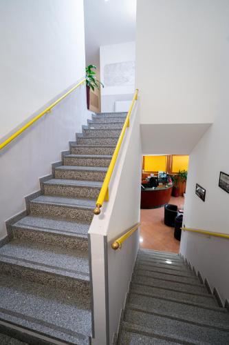 a staircase in a house with a yellow rail at Hotel Cavour Resort in Moncalieri