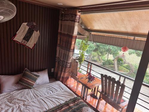 a bedroom with a bed and a balcony with a table at VuLinh Family -Homestay in Yên Bình