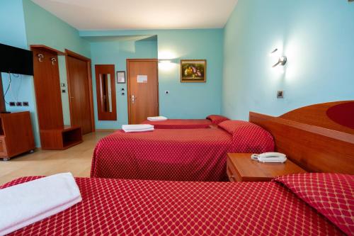 a room with two beds with red sheets at Hotel Cavour Resort in Moncalieri