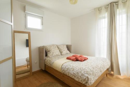 ein Schlafzimmer mit einem Bett mit Spiegel und Fenster in der Unterkunft La Villa Nova Pomponne - 3 chambres et jardin in Magny-le-Hongre