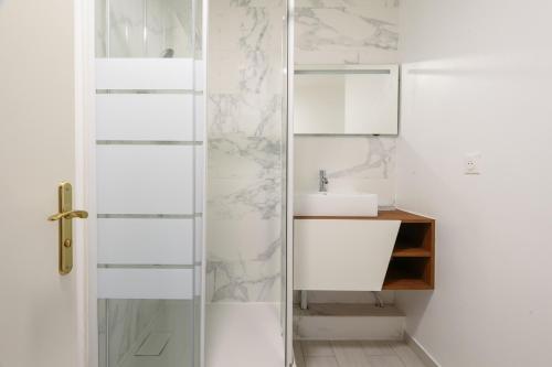 ein Badezimmer mit einer Glastür neben einem Waschbecken in der Unterkunft La Villa Nova Pomponne - 3 chambres et jardin in Magny-le-Hongre