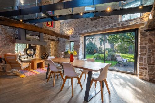 une salle à manger avec une table et des chaises en bois dans l'établissement Gîte La Maison Dorée - Chaumière pour 6, à Brandivy