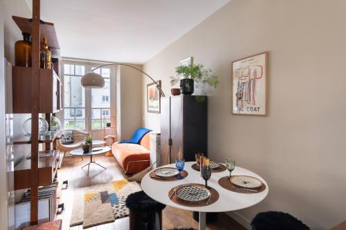 - un salon avec deux tables et un réfrigérateur dans l'établissement Maison Odorico - Logement unique au cœur de Rennes, à Rennes