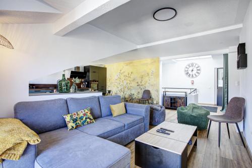 un salon avec un canapé bleu et une table dans l'établissement La Mansarda 305 - Appartement pour 8, à Err