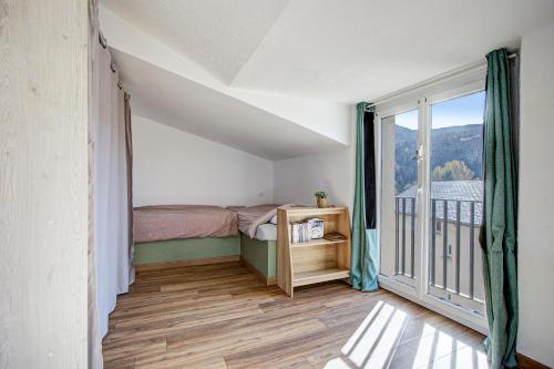 une petite chambre avec un lit et un balcon dans l'établissement La Mansarda 305 - Appartement pour 8, à Err