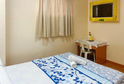 a bedroom with a bed and a small table at RedDoorz at La Briana Guest House Santa Fe, Bantayan Cebu in Bantayan Island