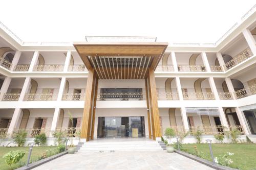 an external view of a large white building with columns at Nirvana Grand Hotel & Resort in Gaya