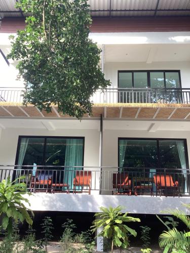 a house with chairs and tables on the balcony at Flower Resort in Koh Tao