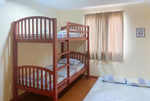 a room with two bunk beds and two beds at RedDoorz at La Briana Guest House Santa Fe, Bantayan Cebu in Bantayan Island