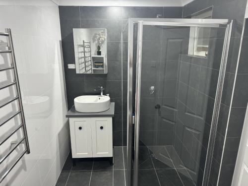 a bathroom with a sink and a glass shower at Deer Valley Farm Stay Illawarra sleeps up to 9 in Kembla Grange