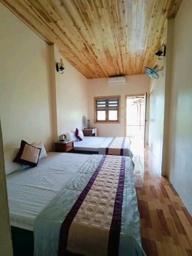 a bedroom with two beds and a wooden ceiling at Moc's House bắc hà in Bắc Hà