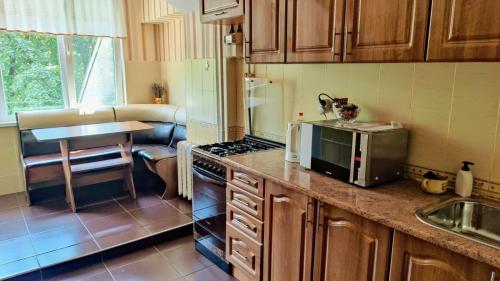 Una cocina con gabinetes de madera, microondas y fregadero. en Центр Рышкановки, en Chişinău