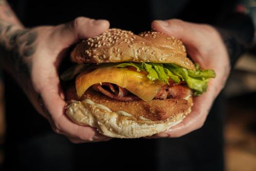 a person holding a hamburger in their hands at Tullah Lakeside Lodge in Tullah