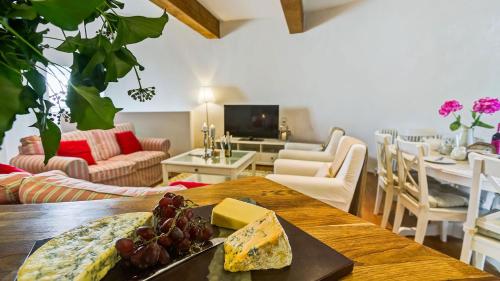 a living room with a table with a plate of cheese at Melin Y Bont in Bodorgan