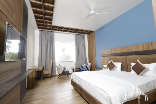 a hotel room with a bed and a desk at Nirvana Grand Hotel & Resort in Gaya