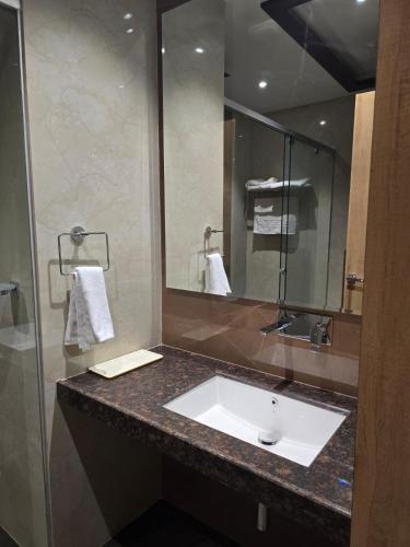 a bathroom with a sink and a mirror at Nirvana Grand Hotel & Resort in Gaya