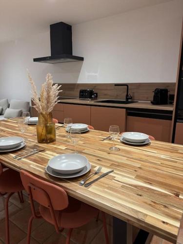 une table en bois avec des assiettes et des verres dans l'établissement Appartement Centre ville, à Porto-Vecchio