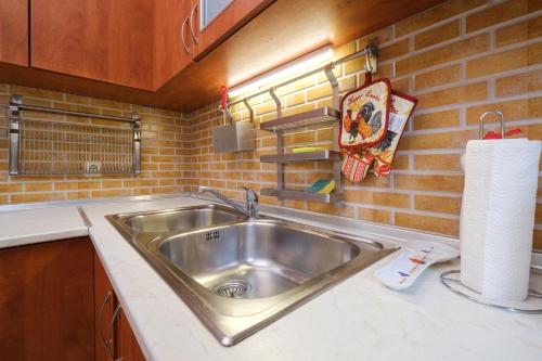 a kitchen with a sink and a brick wall at The Hill House Free Parking in Plovdiv