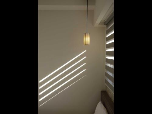 a room with a light fixture and shadows on the wall at Smart Place Inn Kyoto Nijojo-mae Station in Kyoto