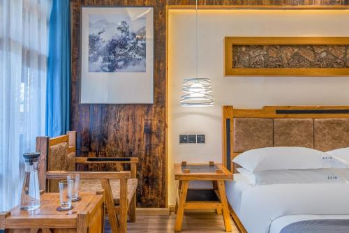 a hotel room with a bed and a table and a bed sidx sidx at 夕露古城中心店 XILU INN NANXI - Ancient City Center Branch in Lijiang