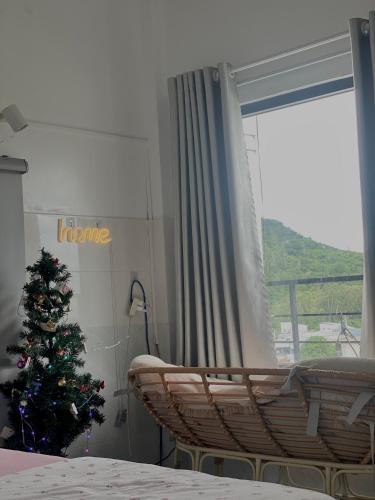 a room with a christmas tree in front of a window at Homestay Tuyết Trinh in Nha Trang