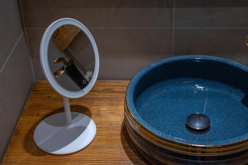 a mirror sitting on a table next to a blue tub at 夕露古城中心店 XILU INN NANXI - Ancient City Center Branch in Lijiang