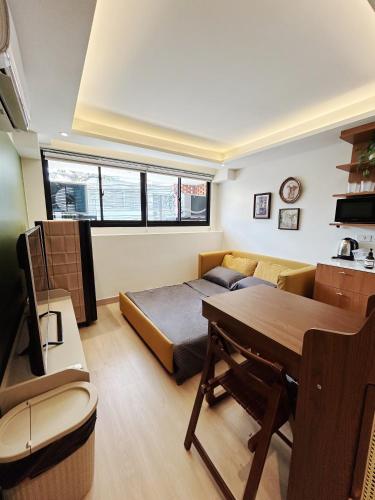 a room with a bed and a desk and a table at Brix26 in Bangkok