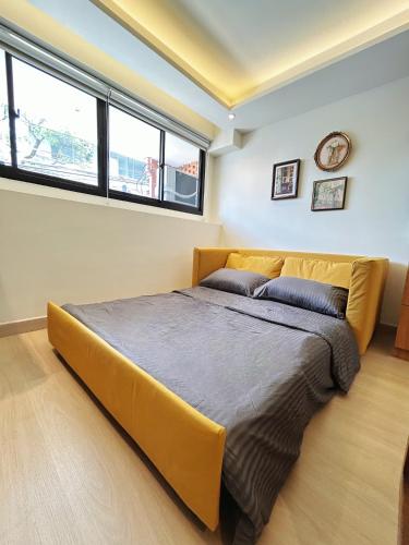 a large bed in a room with two windows at Brix26 in Bangkok