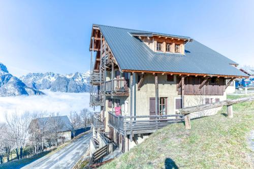 a house on a hill with mountains in the background at Chalet le Regain in Villard-Reculas