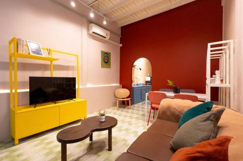a living room with a couch and a television at Siam Twin Charoenkrung in Bangkok