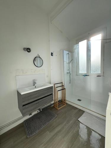 a white bathroom with a sink and a shower at Appartement à 50m de la Plage in Arcachon