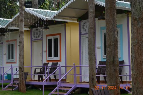a house that is painted purple and yellow at SS Tiny Home Stays in Kolli Hills