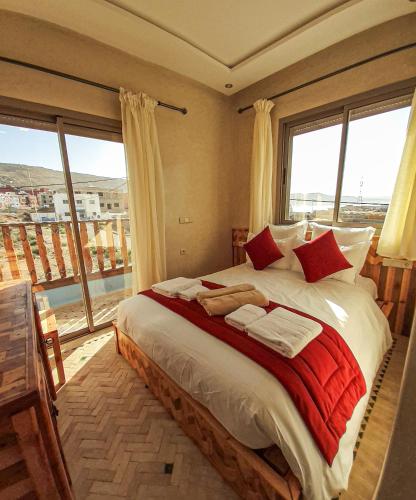 a bedroom with a large bed with a large window at Imsouane WOOD HOUSE in Imsouane
