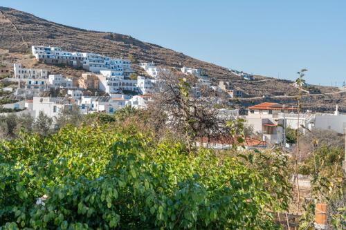 a group of white buildings on a hill with trees at Katerina Irida Kythnos in Mérikhas