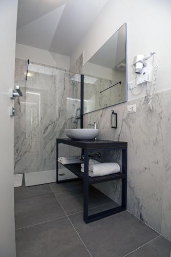 a bathroom with a sink and a mirror at Franciacorta Karting Rooms in Castrezatto
